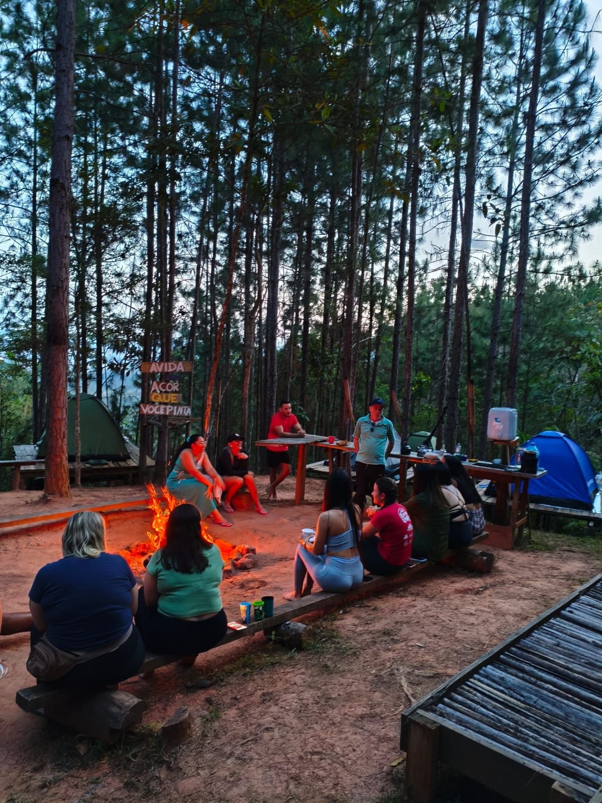 Mesa de café da manhã farto no camping com barracas ao fundo
