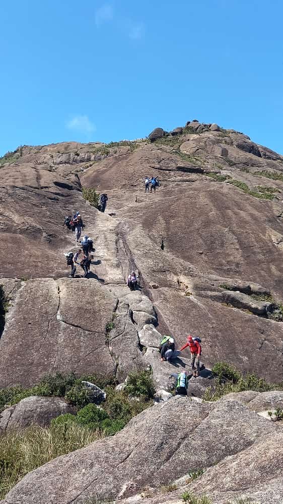 Grupo subindo a face de rocha rumo ao cume do Pico do Marins