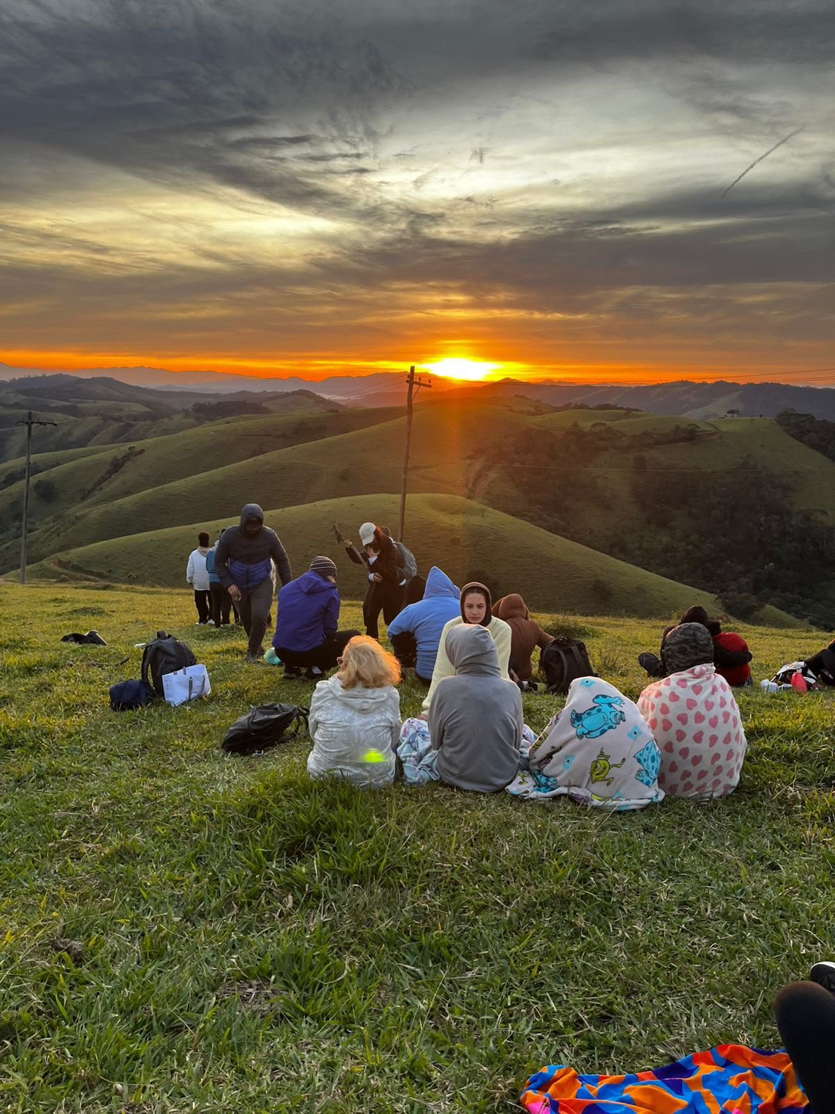 Trilha verde no morro com participantes ao fundo