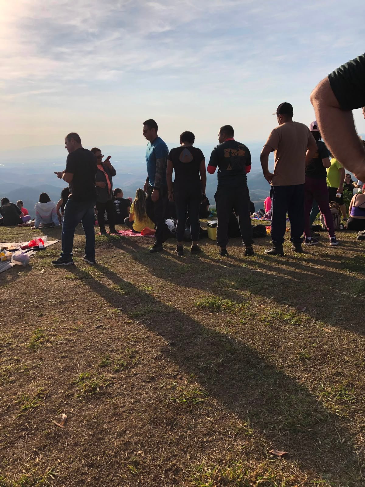 Grupo assistindo o pôr do sol laranja com cobertor