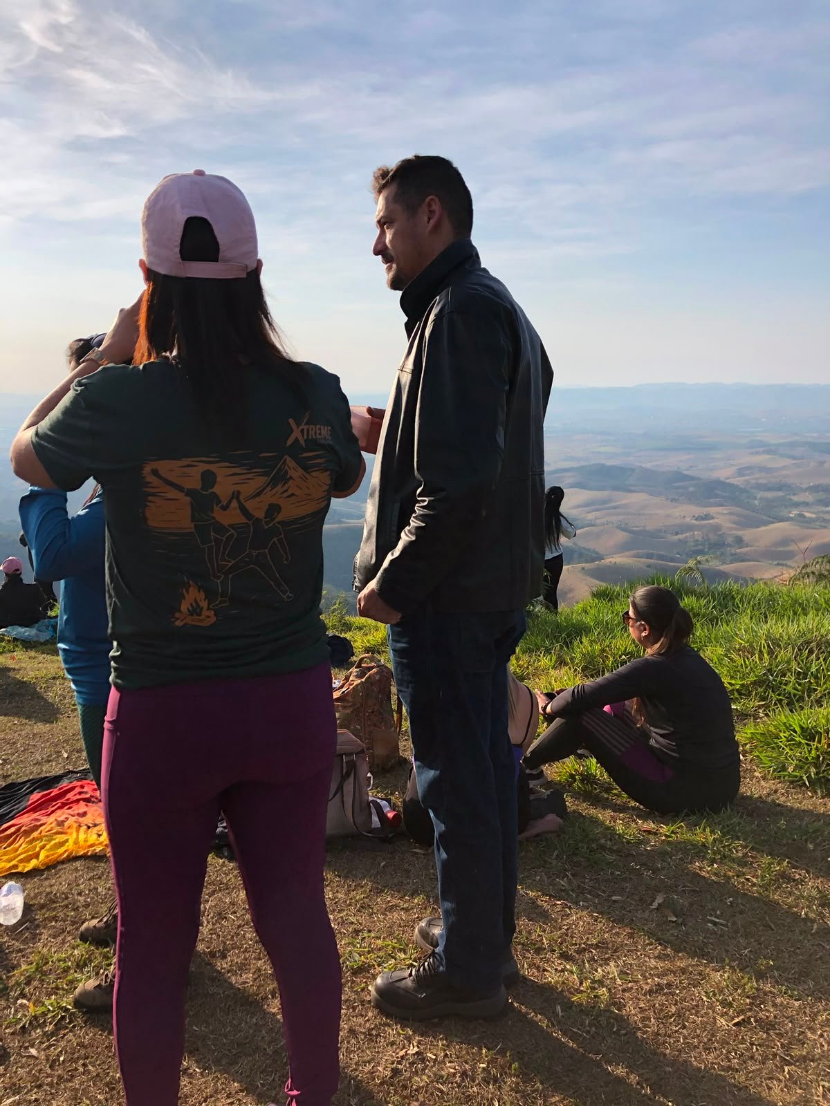 Avô e netinha caminhando no morro com mata ao fundo