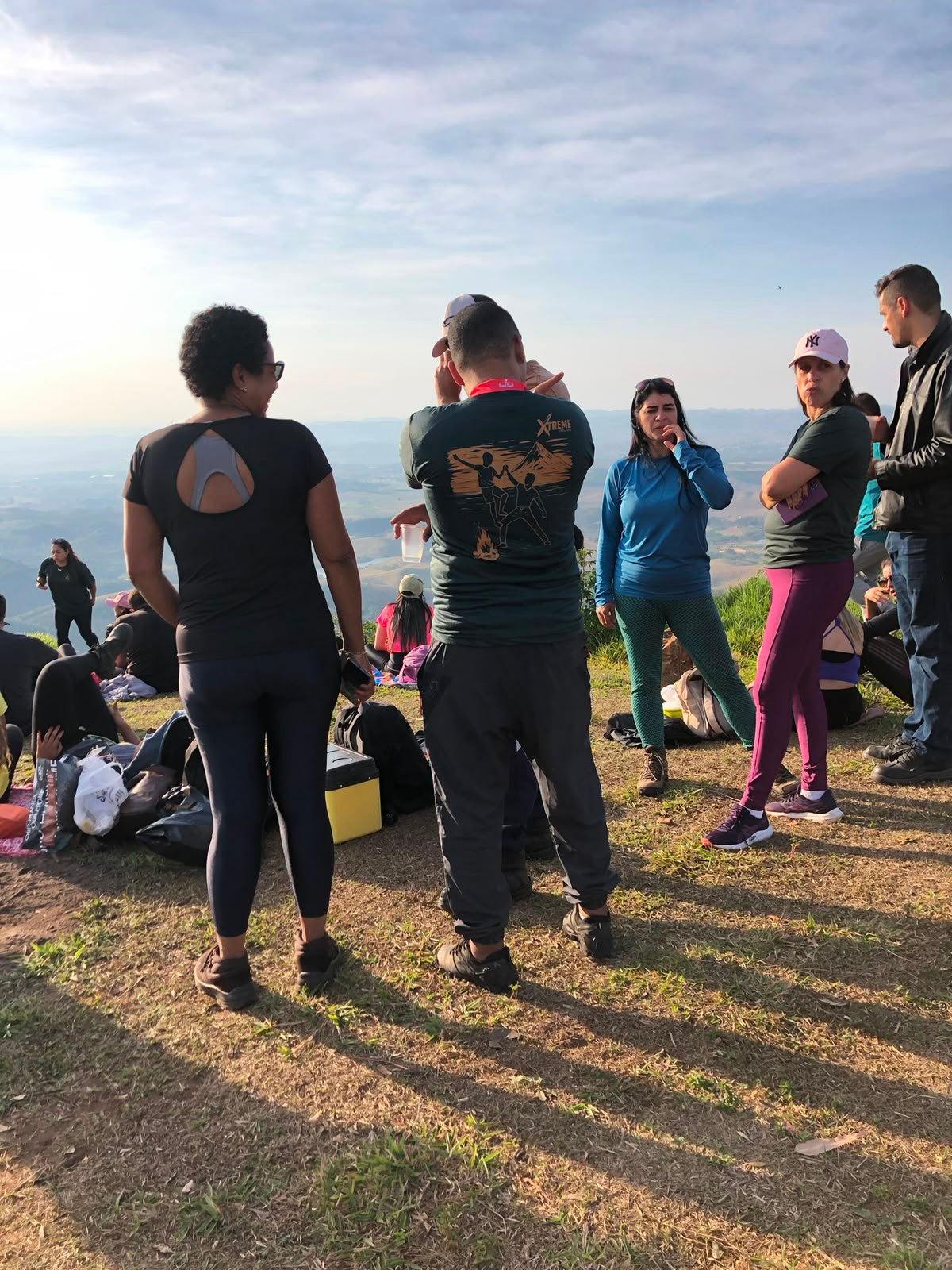 Jovem equilibrando na rocha com grupo ao redor