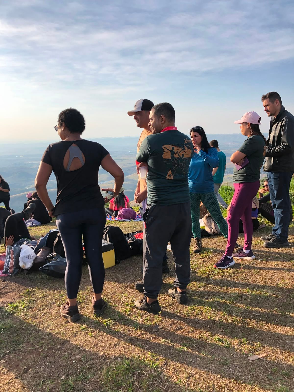 Trilha de terra vermelha descendo o morro verde
