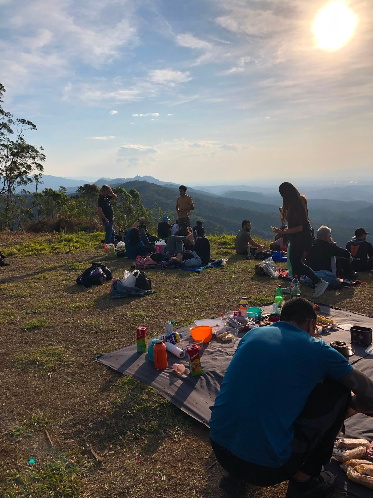 Pôr do sol laranja intenso com grupo sentado