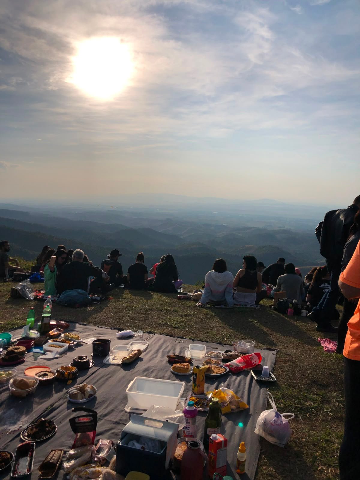 Grupo de participantes com sombras longas ao pôr do sol